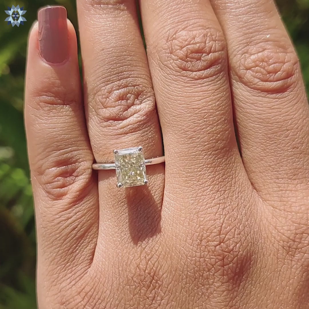 Custom moissanite engagement ring in light yellow with 4 prong setting and white gold band.
