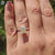 Custom moissanite engagement ring in light yellow with 4 prong setting and white gold band.