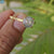 Moissanite ring in 4 prong yellow gold setting.