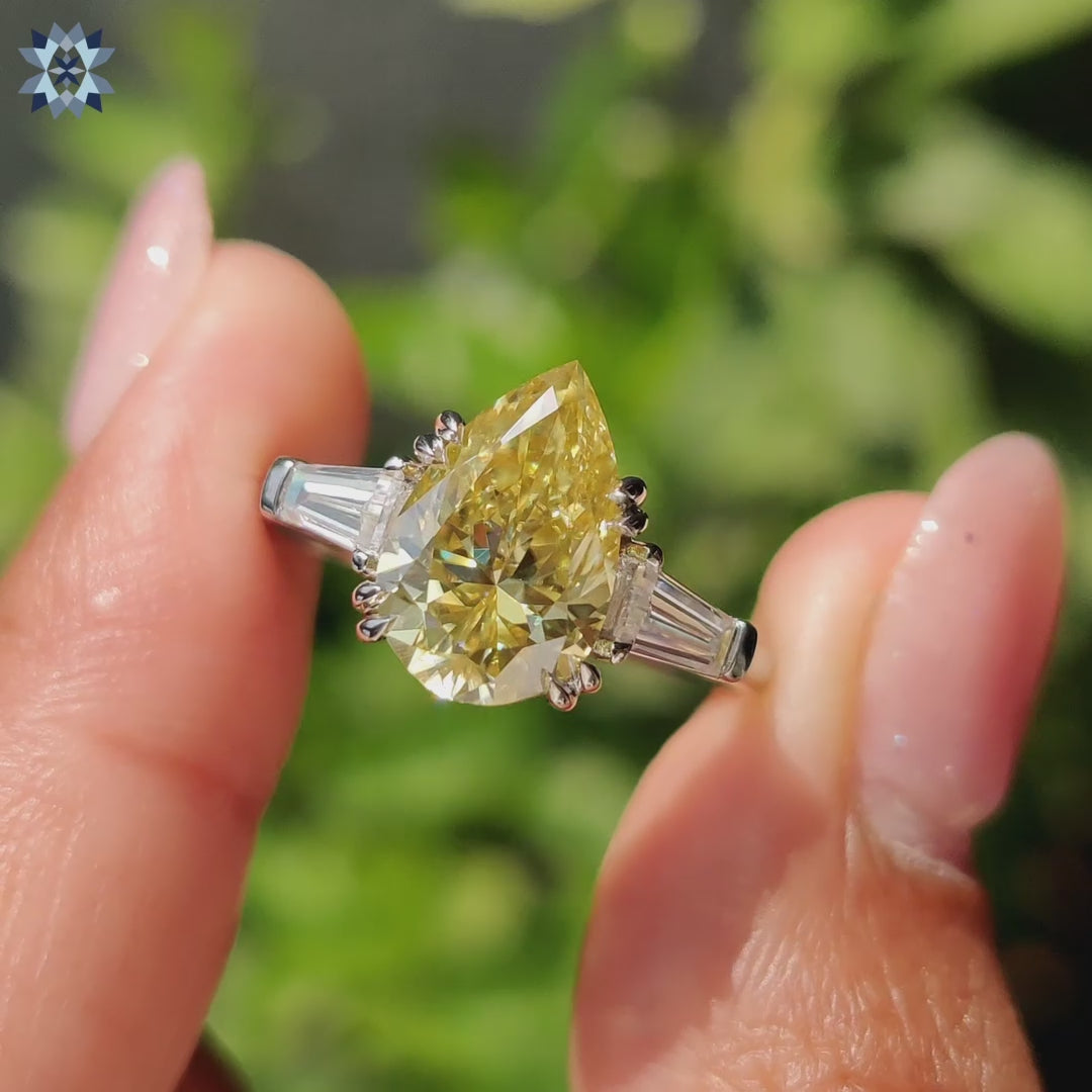 Pear three stone engagement ring with canary yellow Moissanite and double claw prong setting.