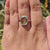 Custom solitaire ring featuring bezel set cyan cushion moissanite.