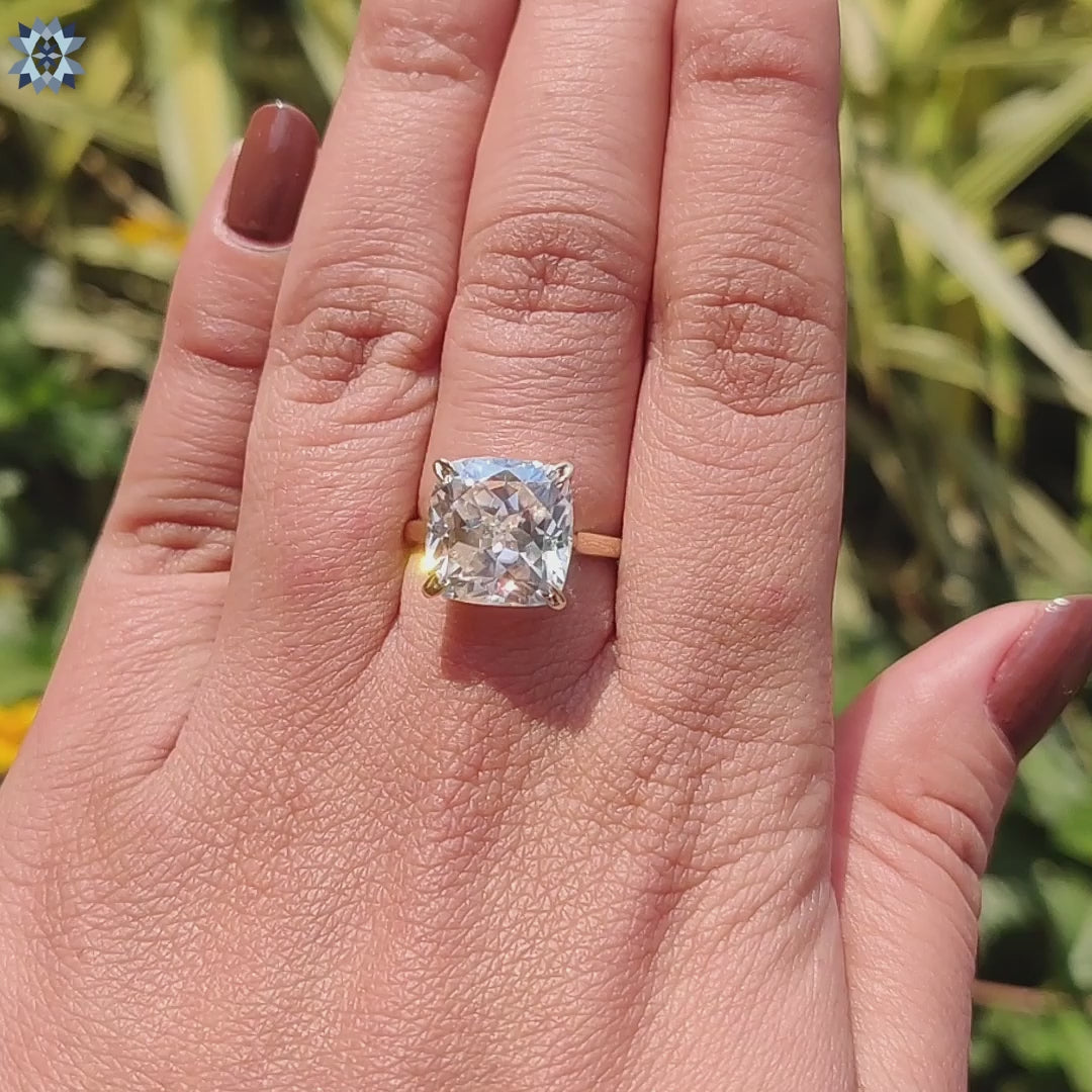 4 prong cushion moissanite ring crafted in yellow gold.