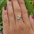 Aqua blue green moissanite set in yellow gold solitaire ring.