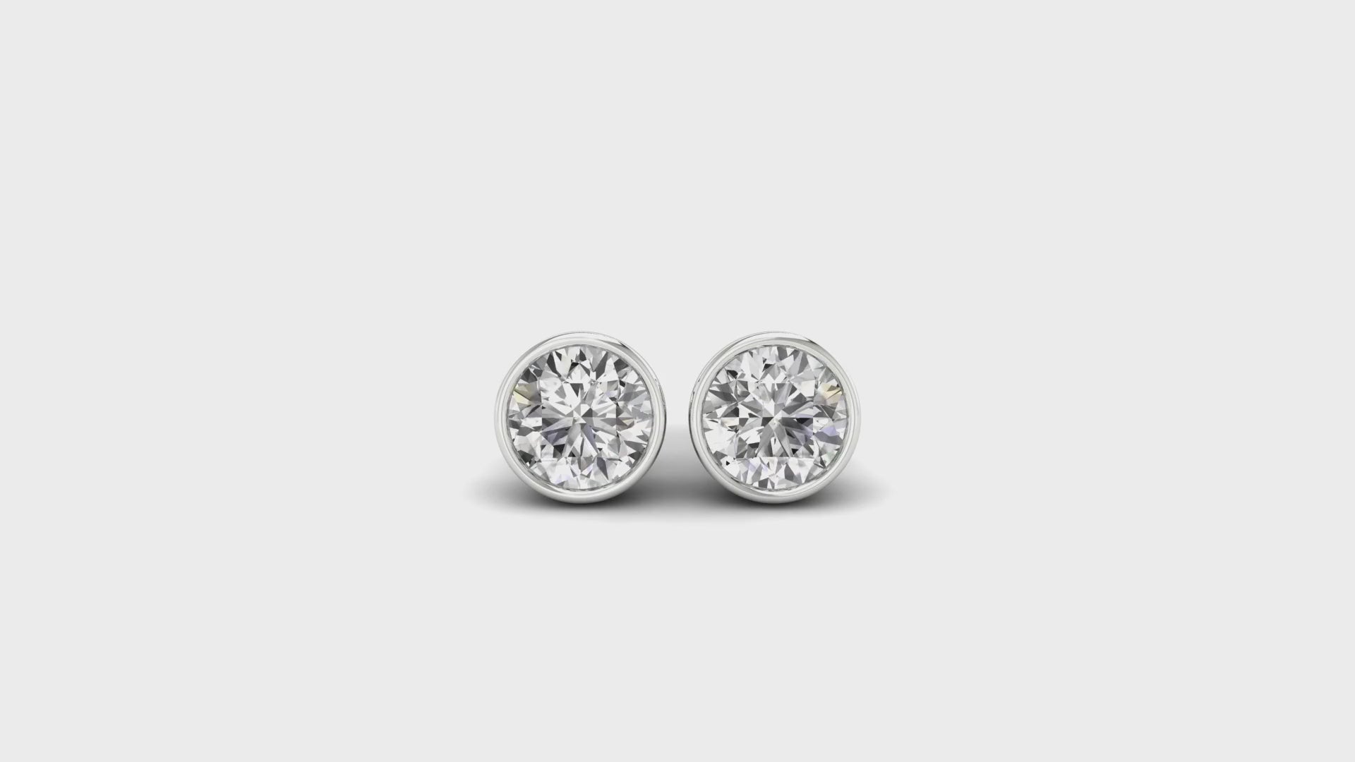 Round cut diamond earrings in white gold bezel setting.