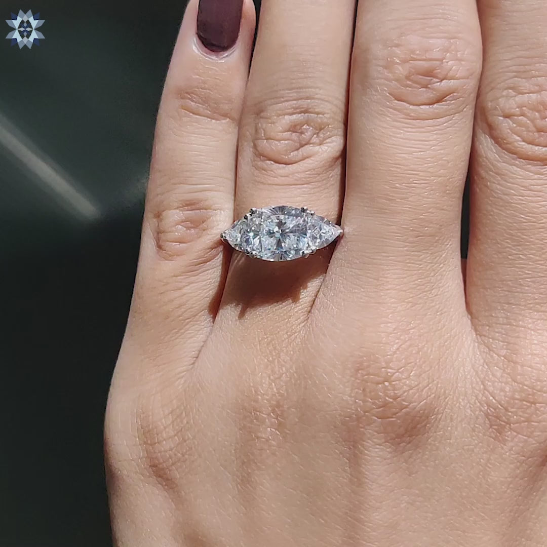 Cushion cut moissanite in white gold with side stones.