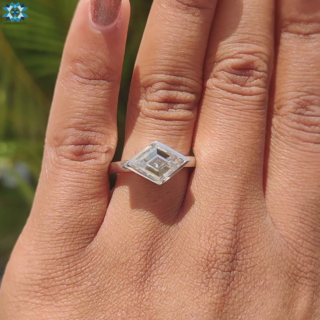 White gold ring with lozenge cut moissanite center stone.