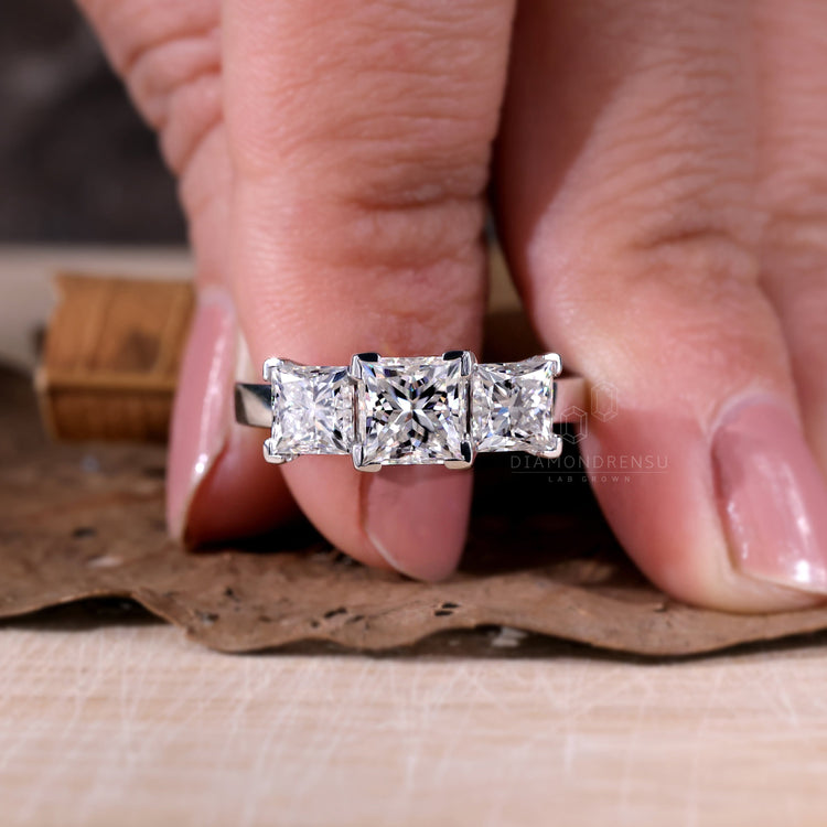 Princess diamond cut in a breathtaking three stone design.