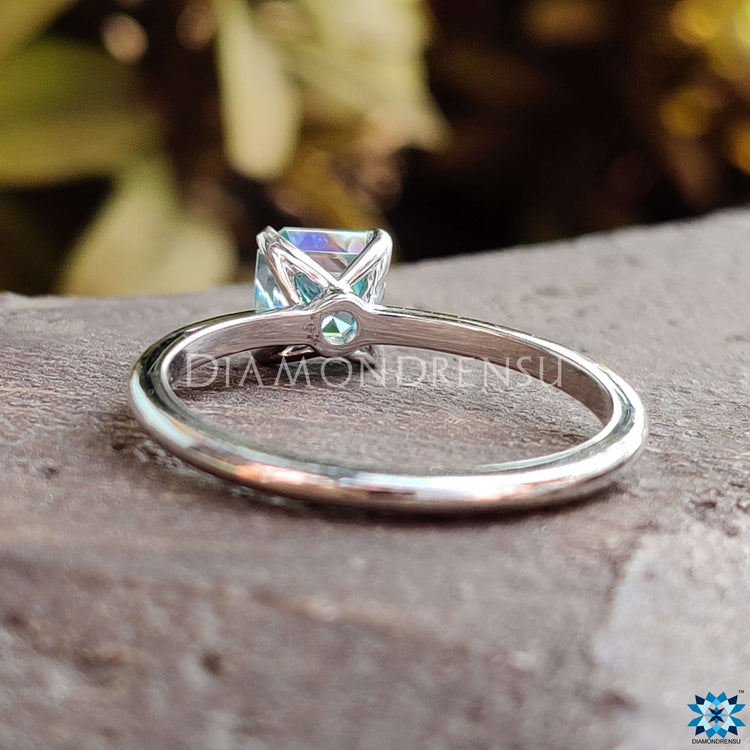Unique moissanite engagement ring crafted with a cyan blue center stone.