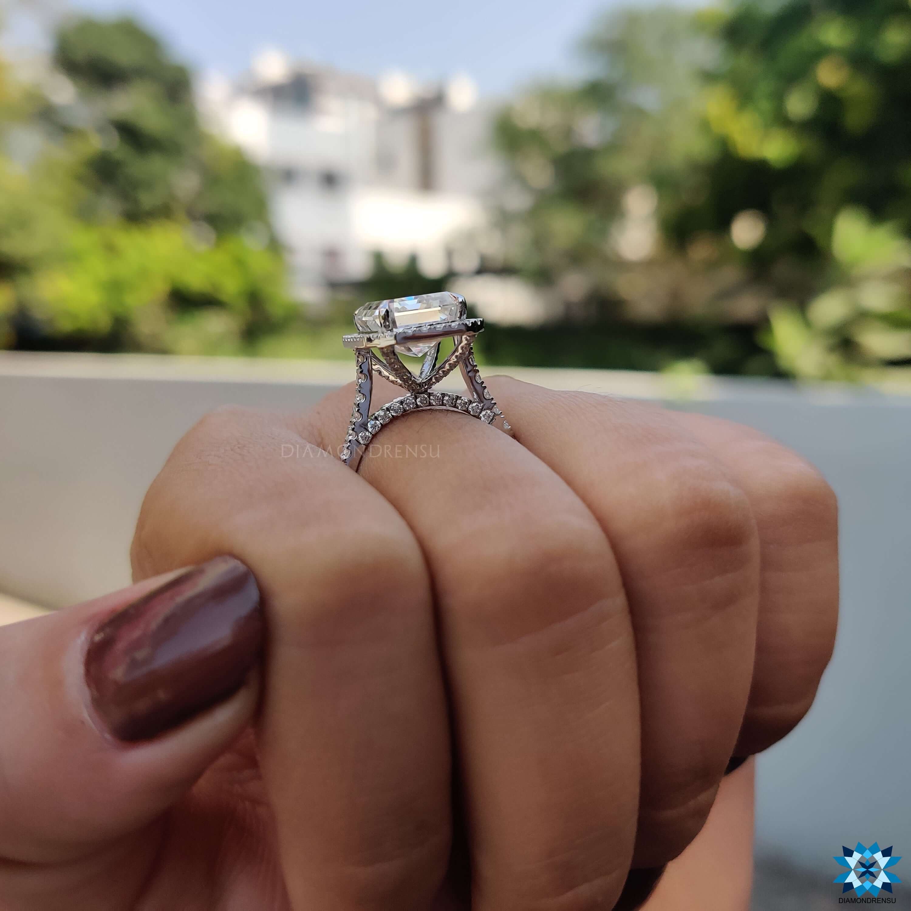 Emerald cut moissanite ring with bridge accent design.