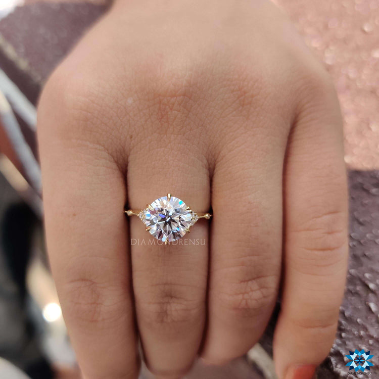 Round cut moissanite ring in muse setting with 4 prong design.
