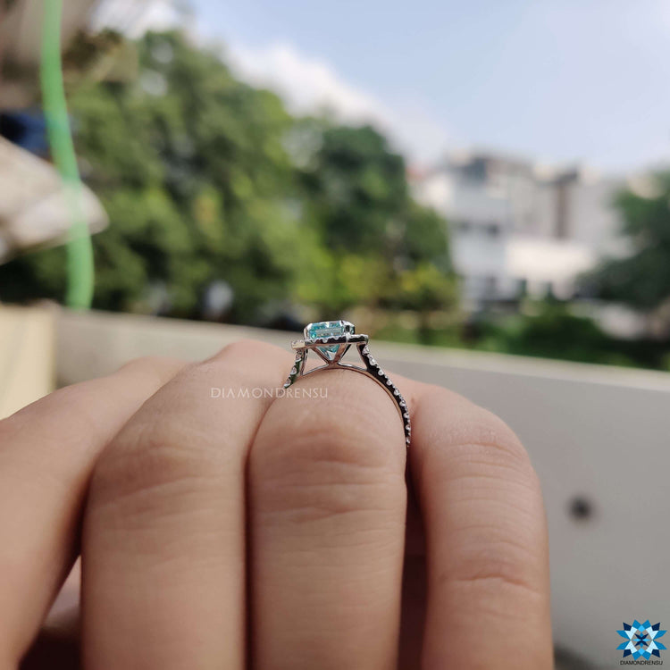 White gold ring featuring radiant blue moissanite and halo.