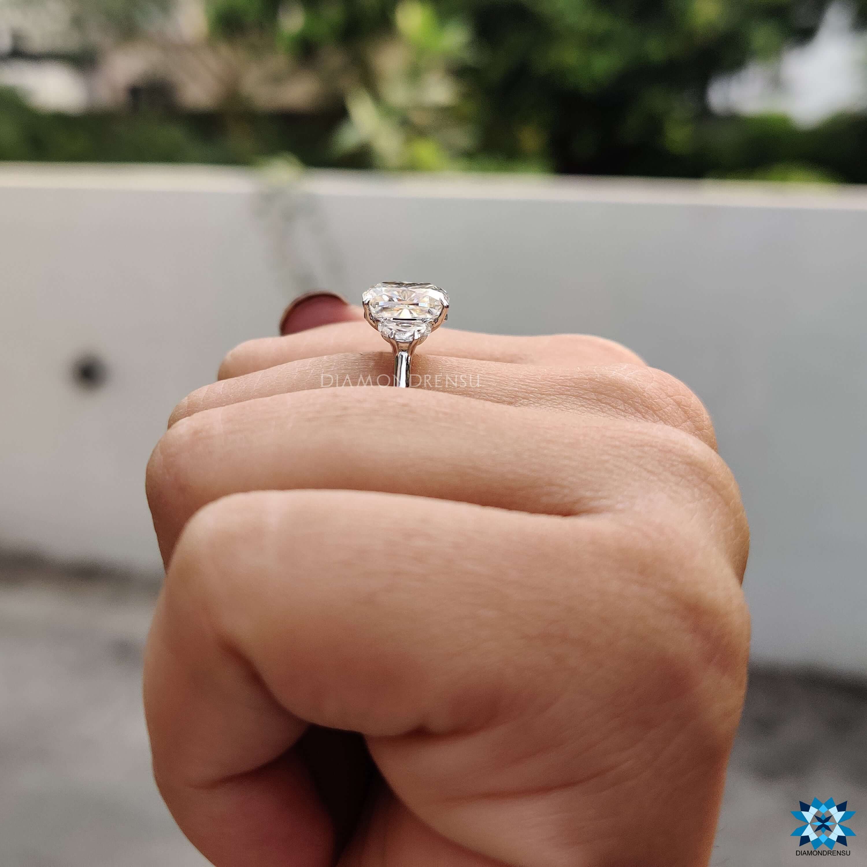 Handmade 3 stone ring with cushion cut moissanite center.