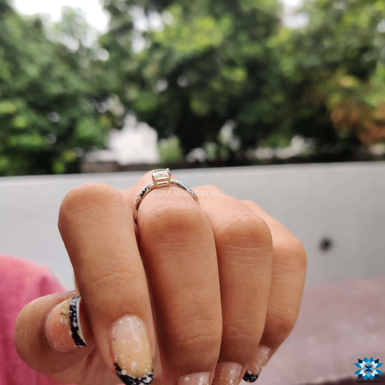 White gold ring with emerald cut moissanite and pave band.