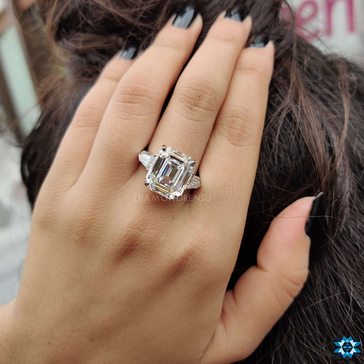 Three stone engagement ring with Krupps emerald center stone.