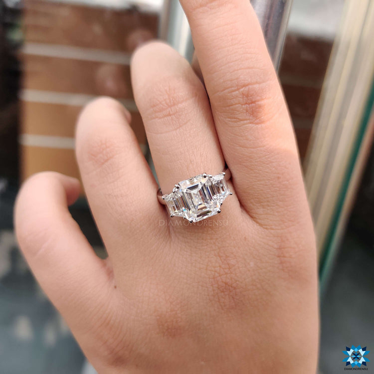 Custom engagement ring with emerald moissanite and trapezoid side stones.