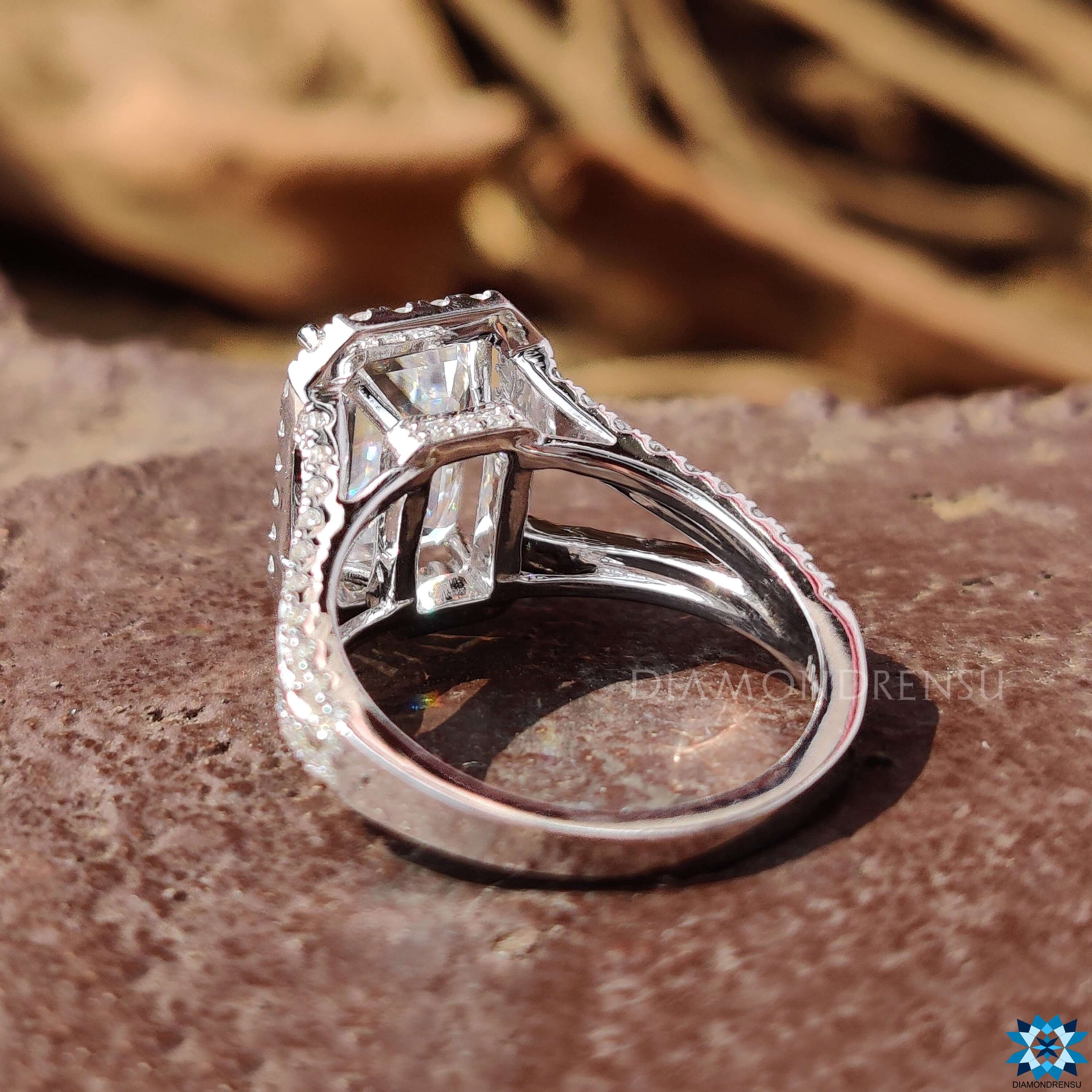 Handmade engagement ring with emerald cut center stone.