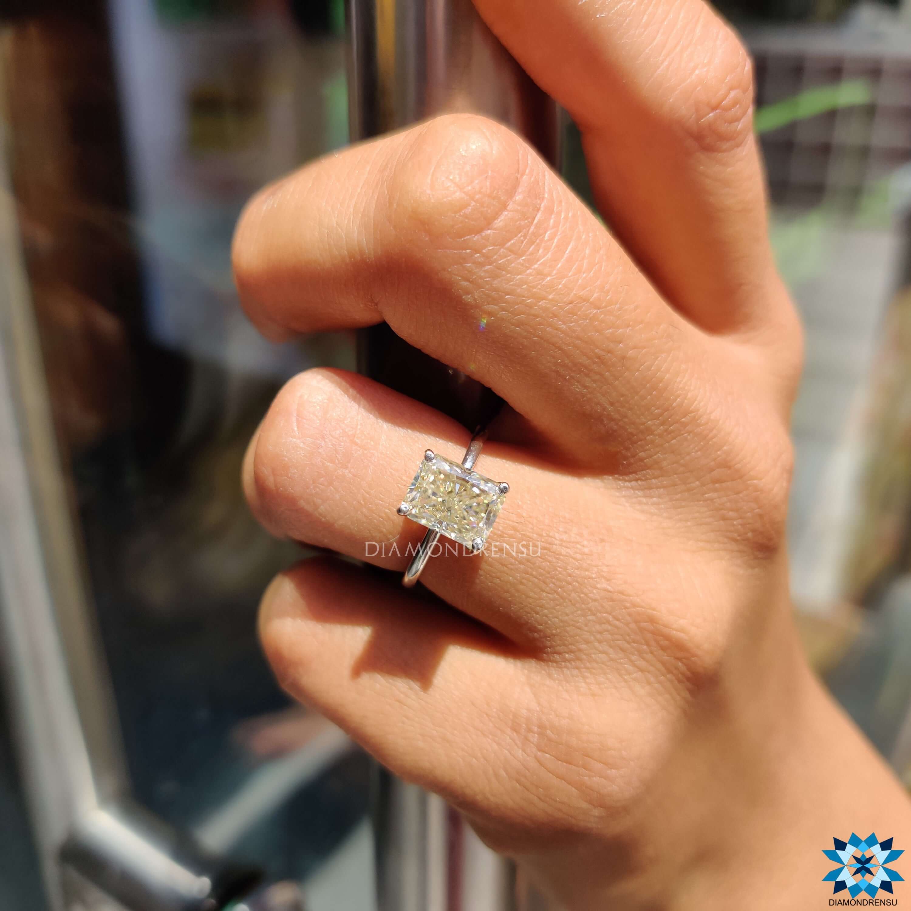 Radiant cut moissanite ring with 4 prong setting and handmade white gold band.