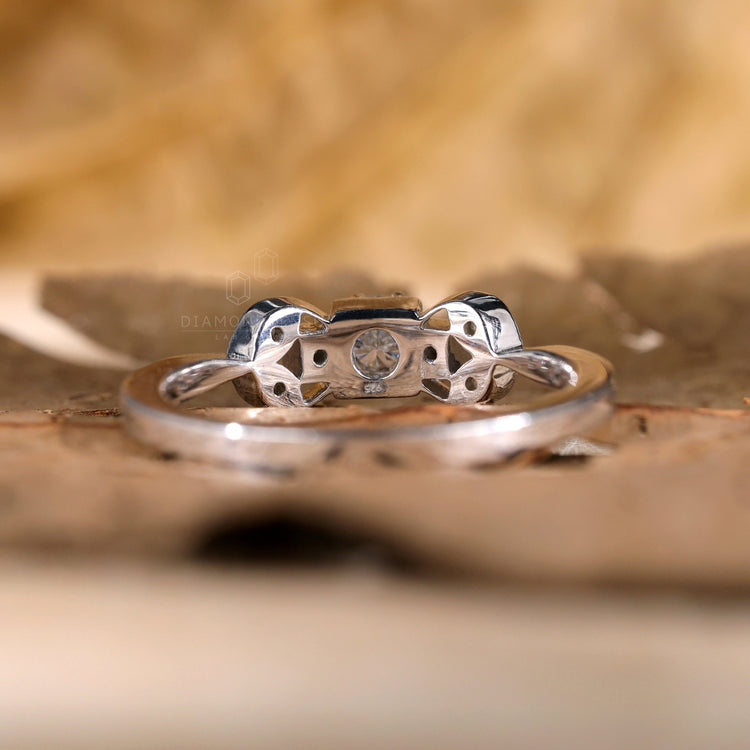 Round cut diamond ring featuring a tapered shank and unique style.