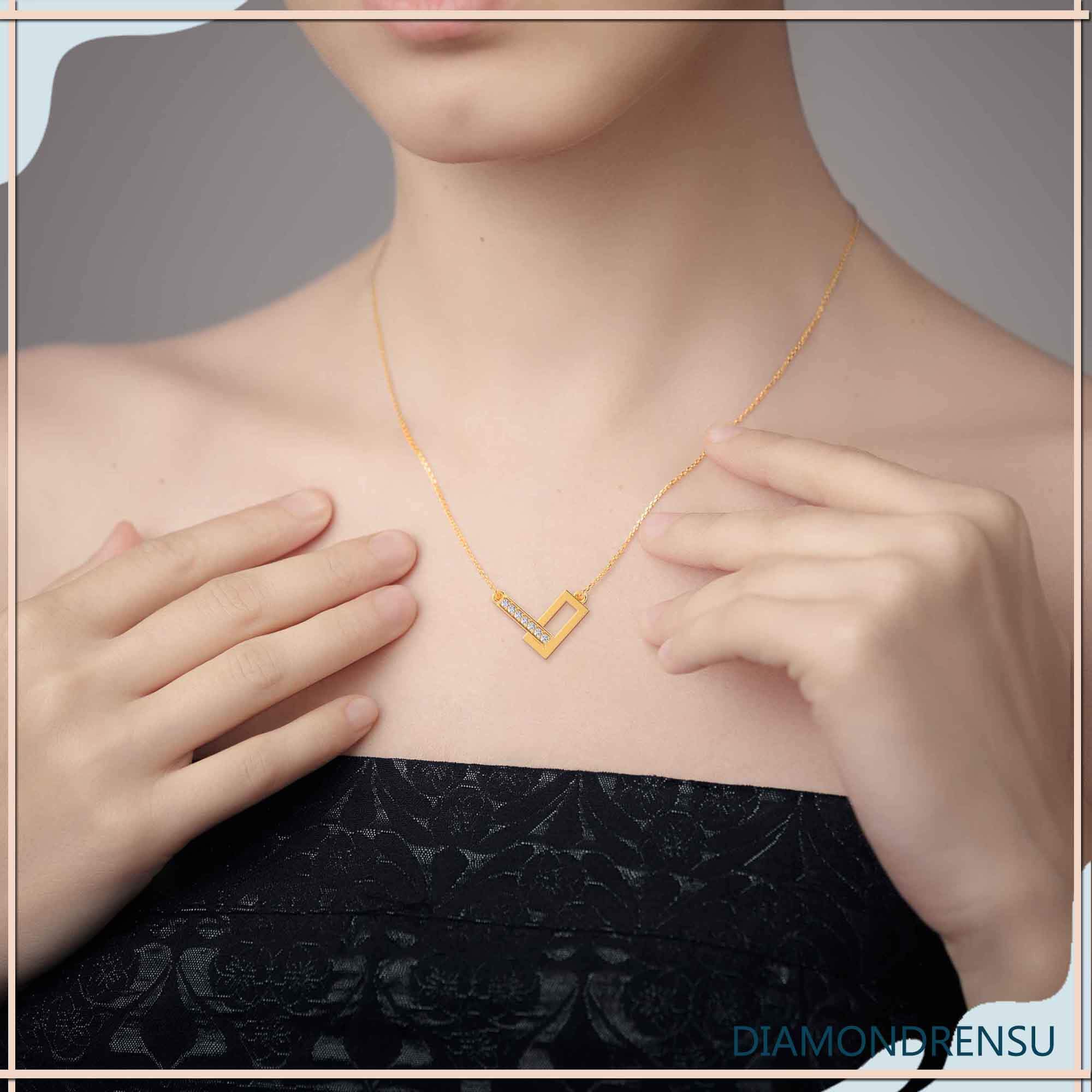 Unique gold pendant with round diamond and V-shaped design.