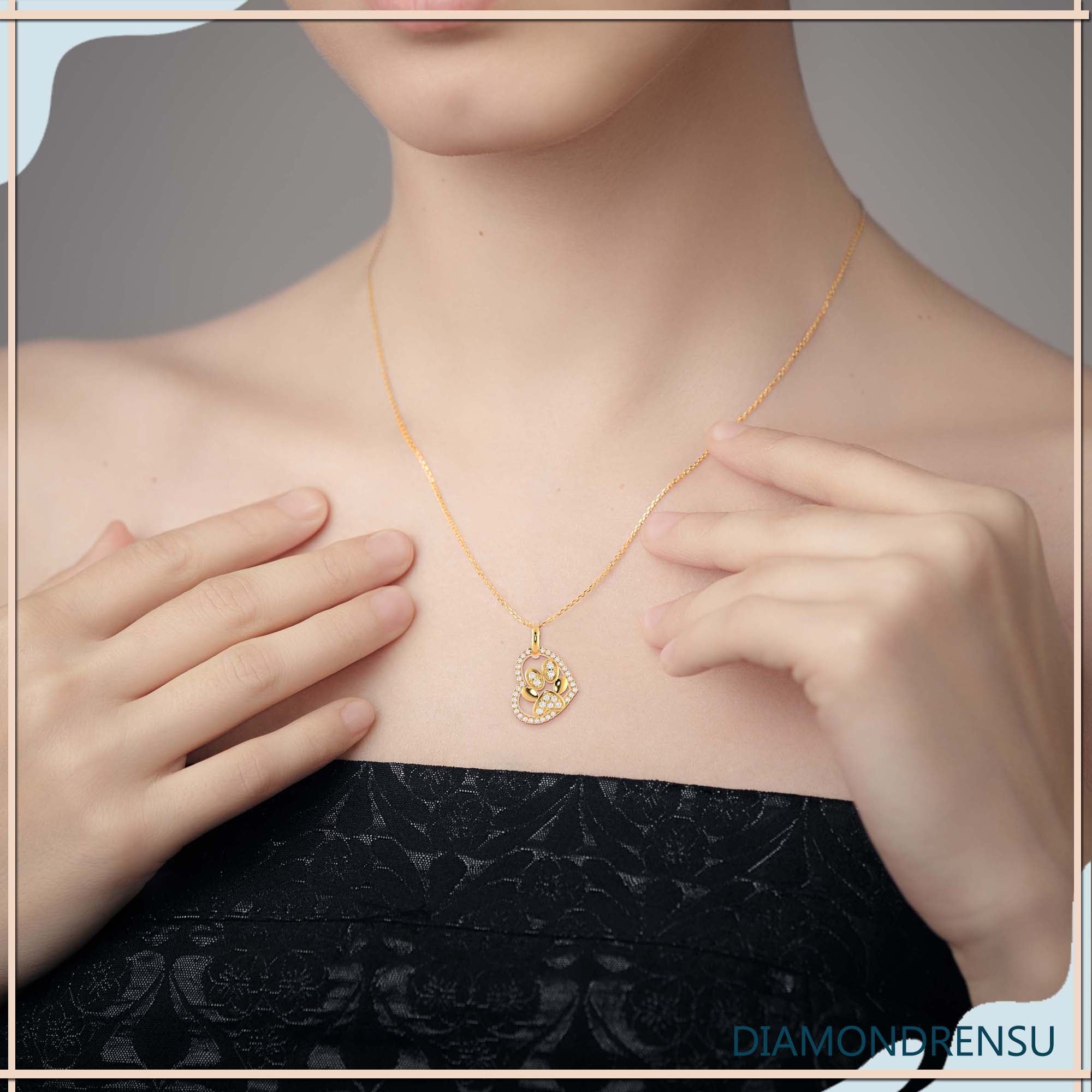 Pendant with heart and paw design in yellow gold finish.