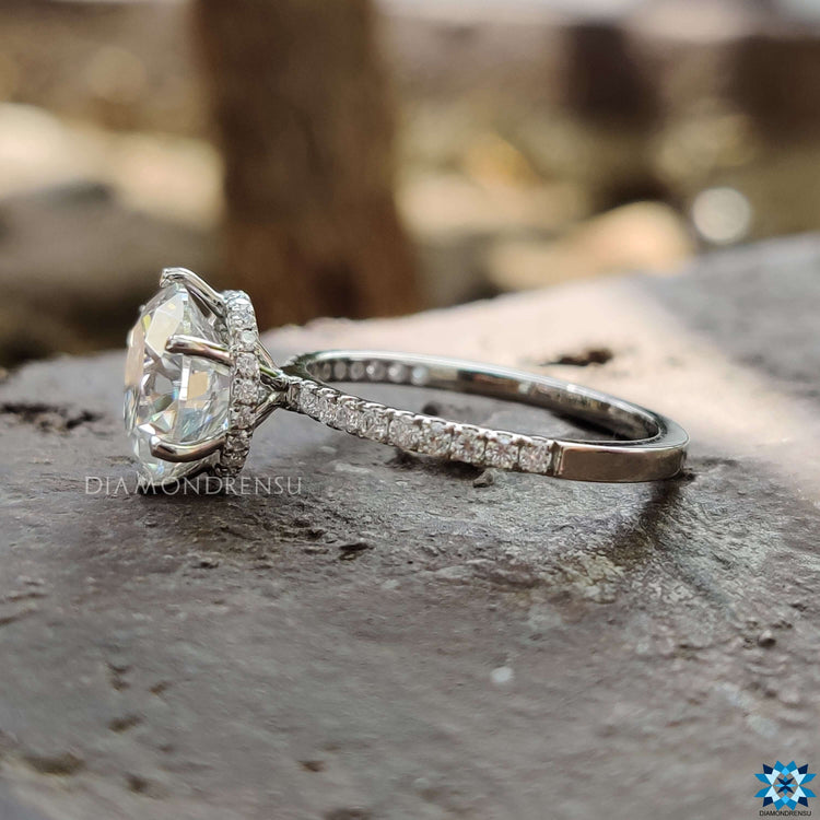 Round cut moissanite ring with pave band in white gold.