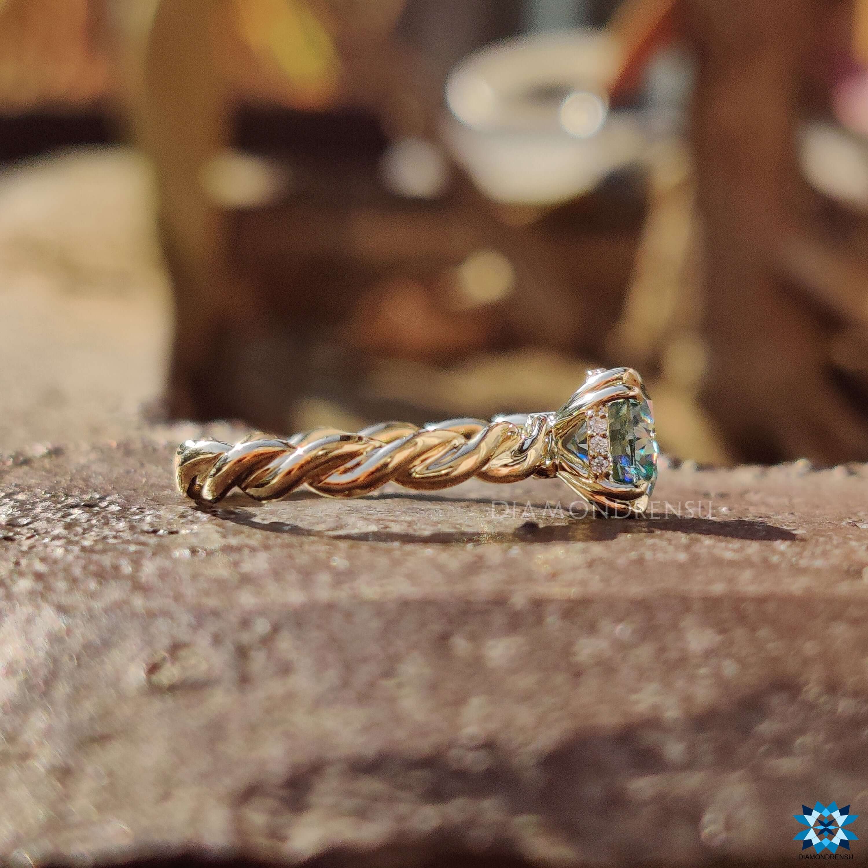 Yellow gold solitaire ring with blue moissanite center stone.