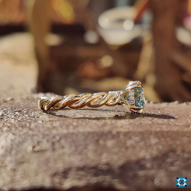Yellow gold solitaire ring with blue moissanite center stone.