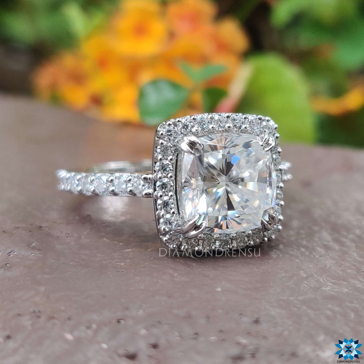 Handmade moissanite ring with double claw prong and pavé band.