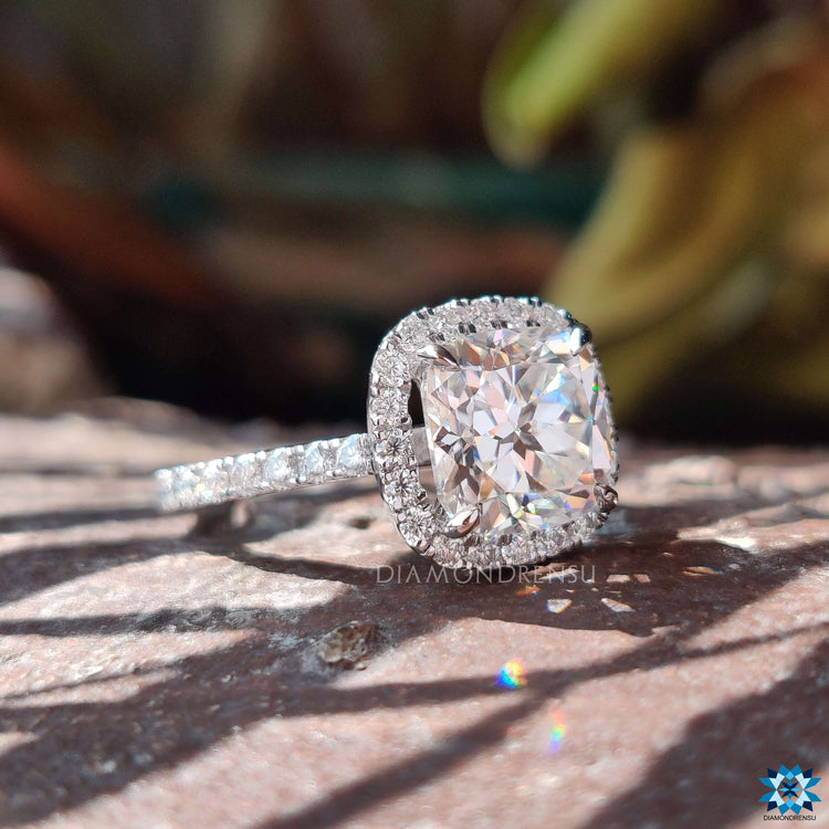 Cushion cut halo engagement ring in cathedral setting.