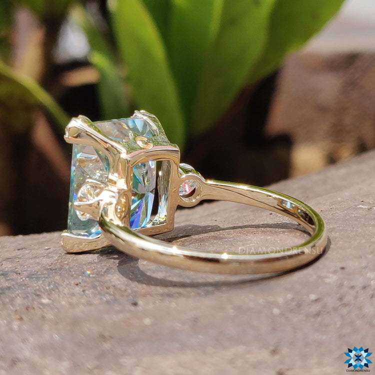 Radiant cut moissanite ring with warm gold band.