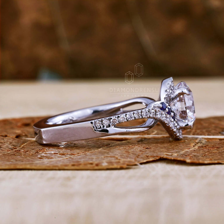 Round cut diamond ring with a side stone engagement design.