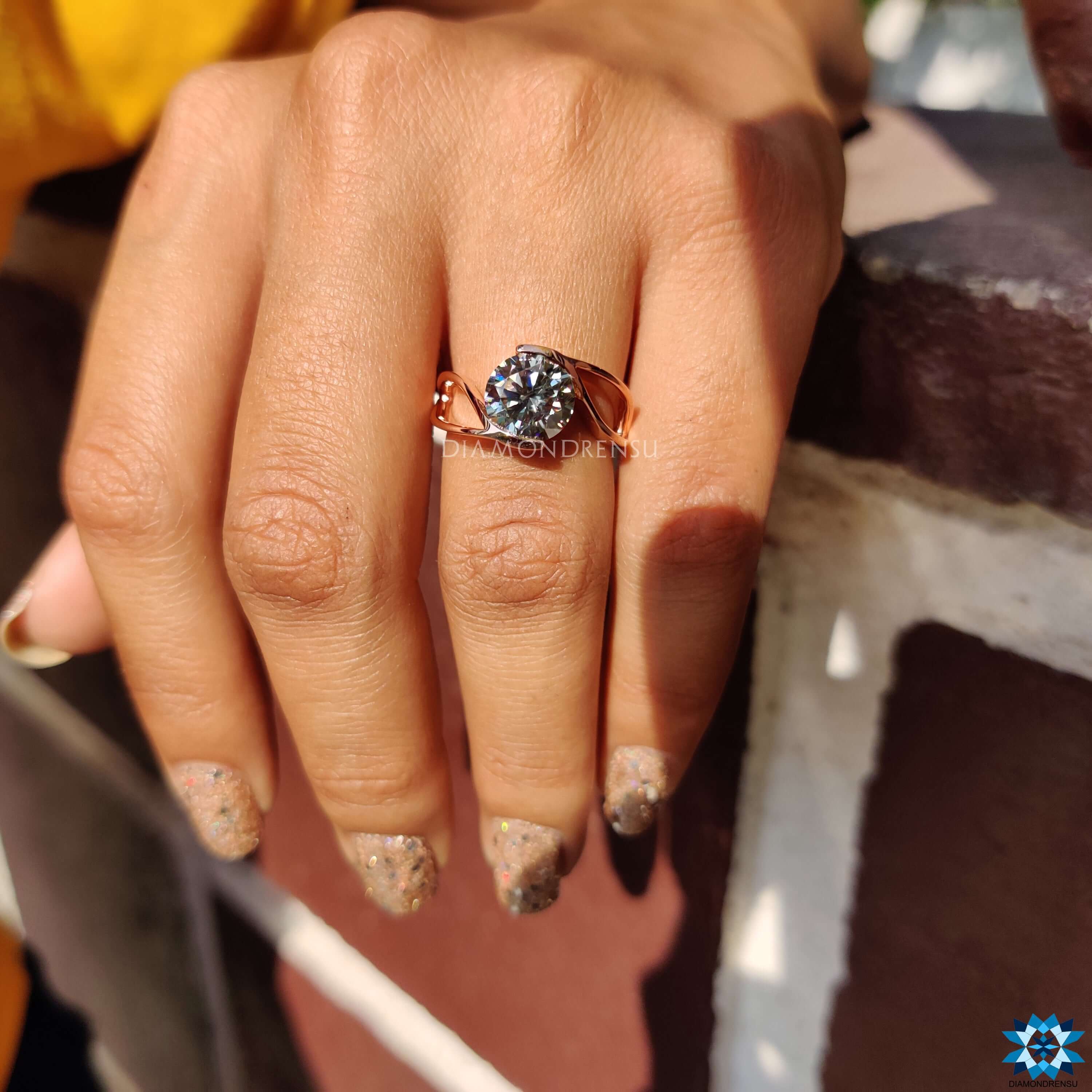 Rose gold solitaire ring with round cut gray moissanite.