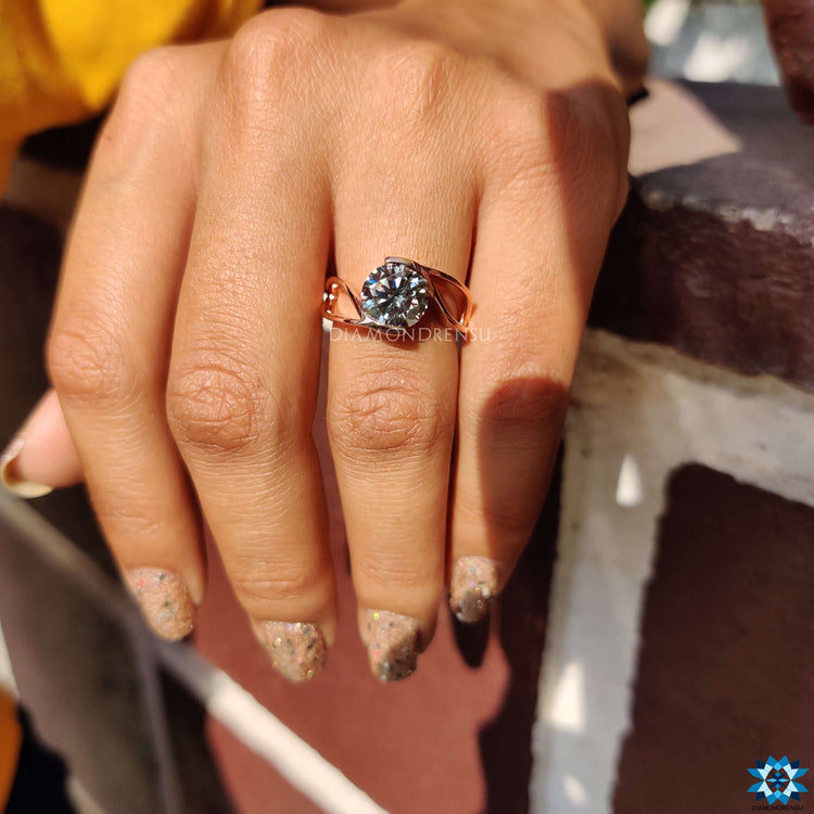 Rose gold solitaire ring with round cut gray moissanite.