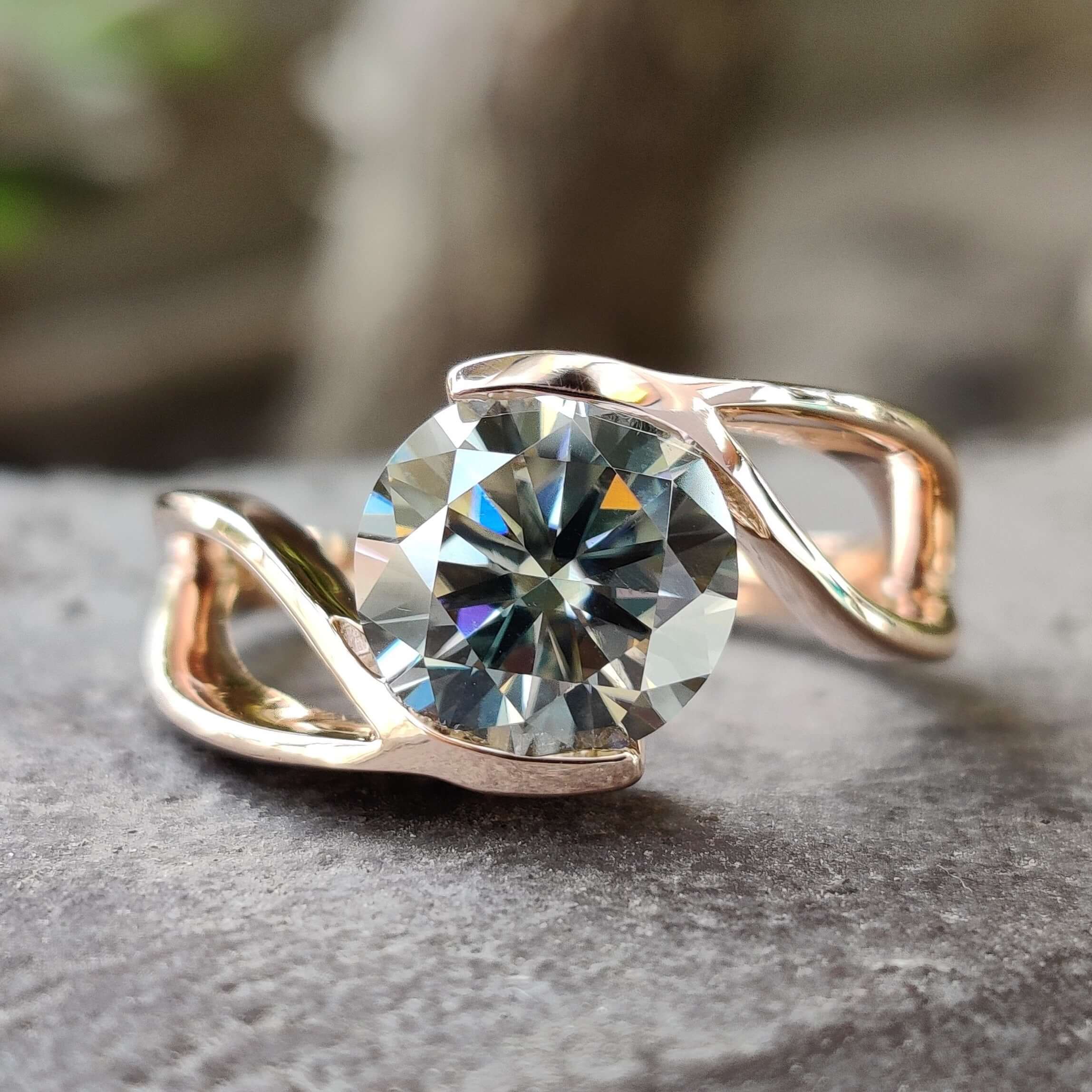 Tension setting engagement ring with round gray moissanite.