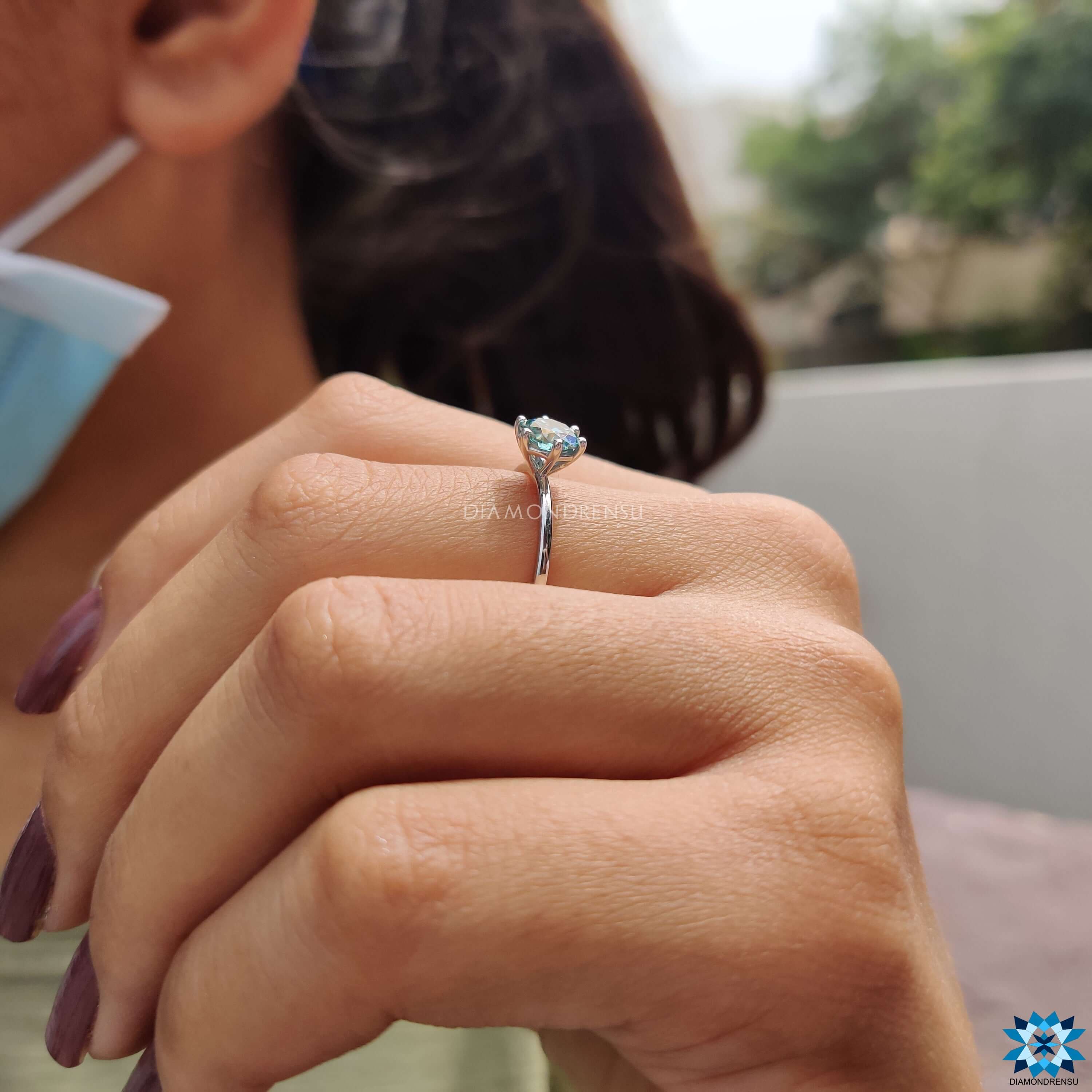 White gold engagement ring with cyan blue moissanite.