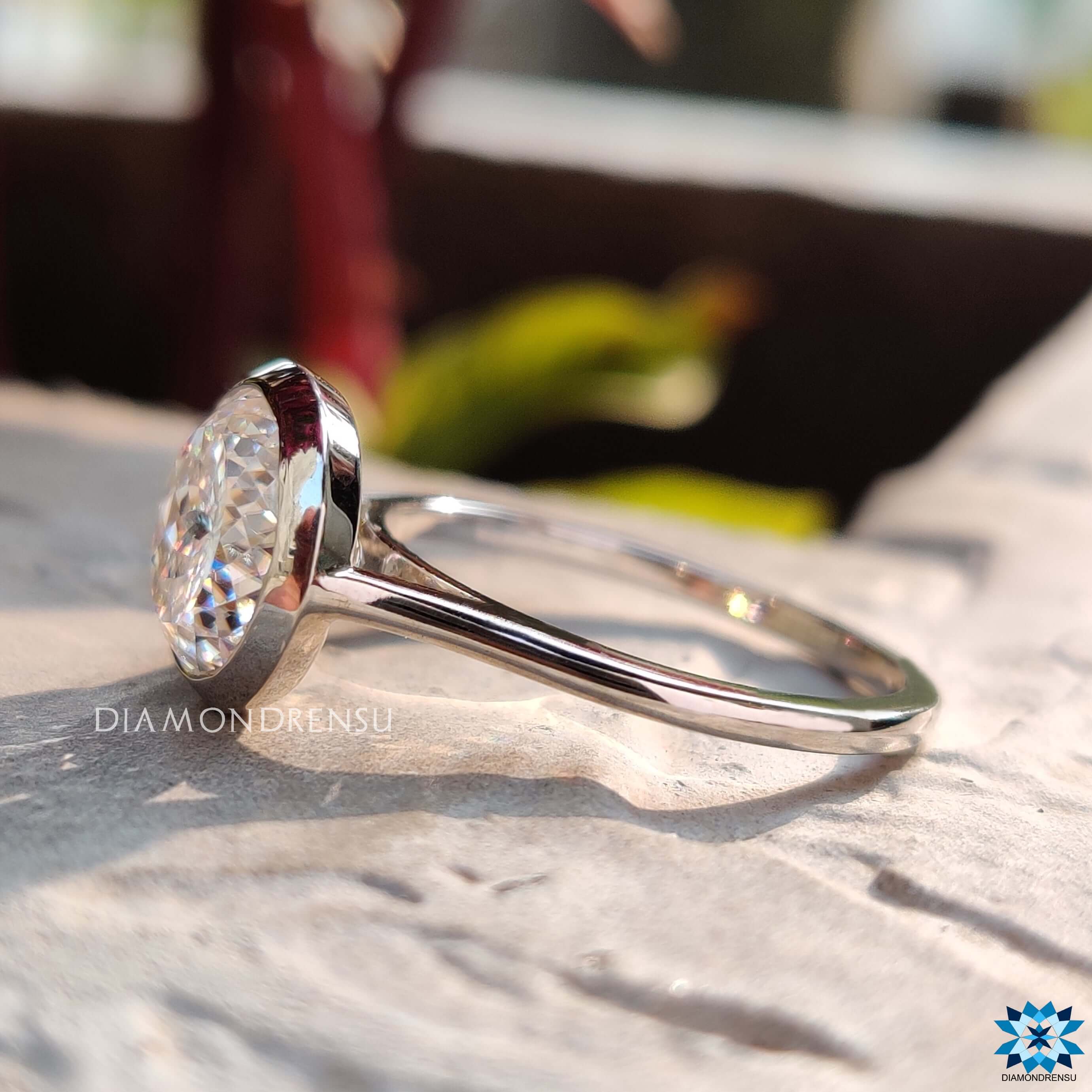 Bezel set Portuguese cut moissanite ring with prong accents.