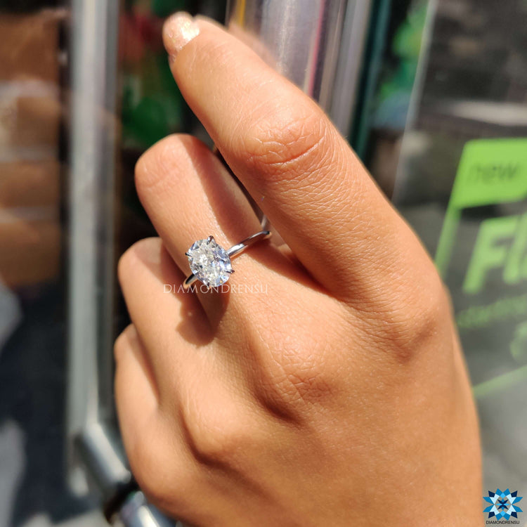 White gold solitaire ring with oval moissanite center.