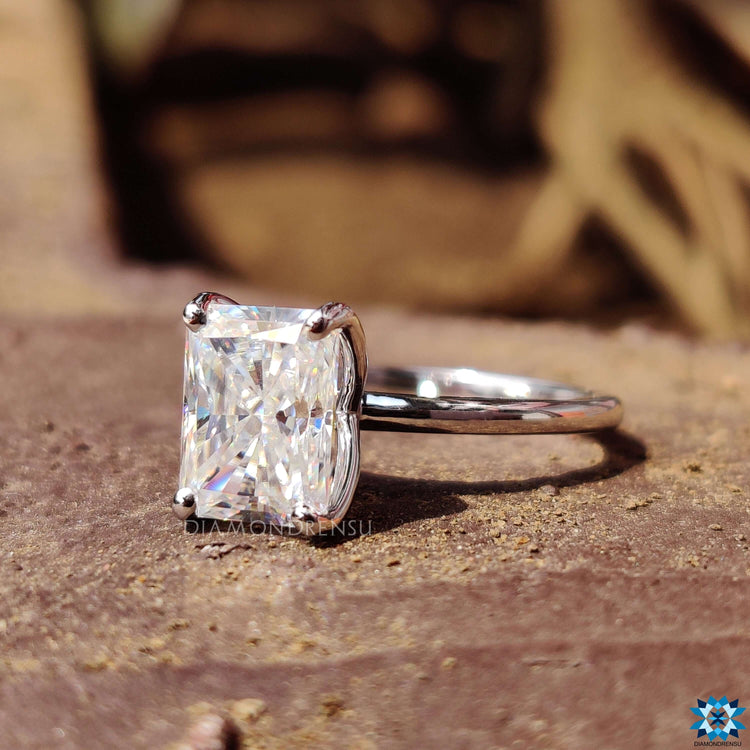 Prong setting ring with radiant cut moissanite in white gold finish.