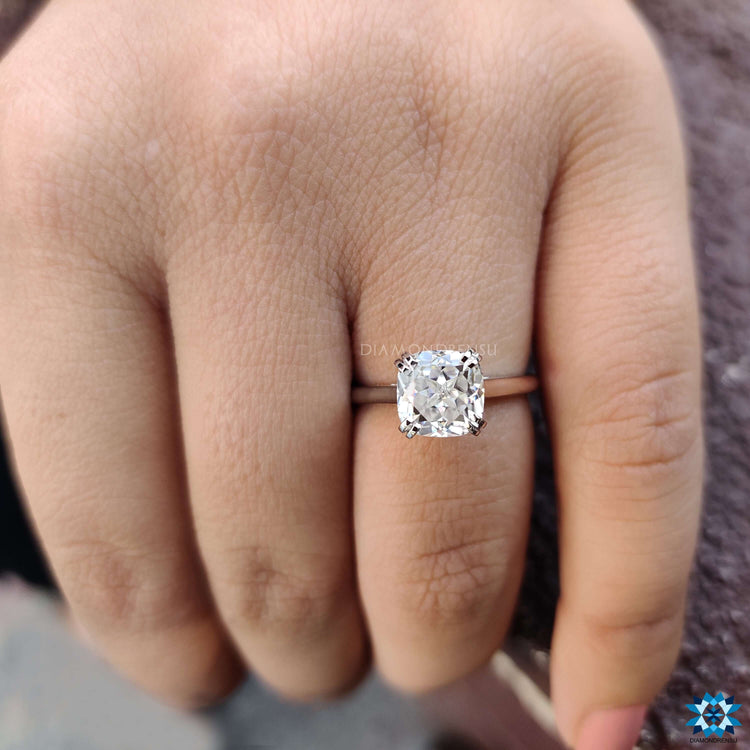 White gold engagement ring with cathedral setting and cushion Rensu stone.