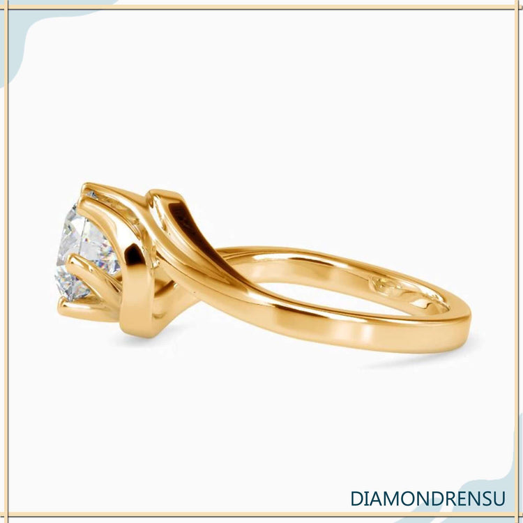 Yellow gold diamond ring in a unique bypass solitaire design.