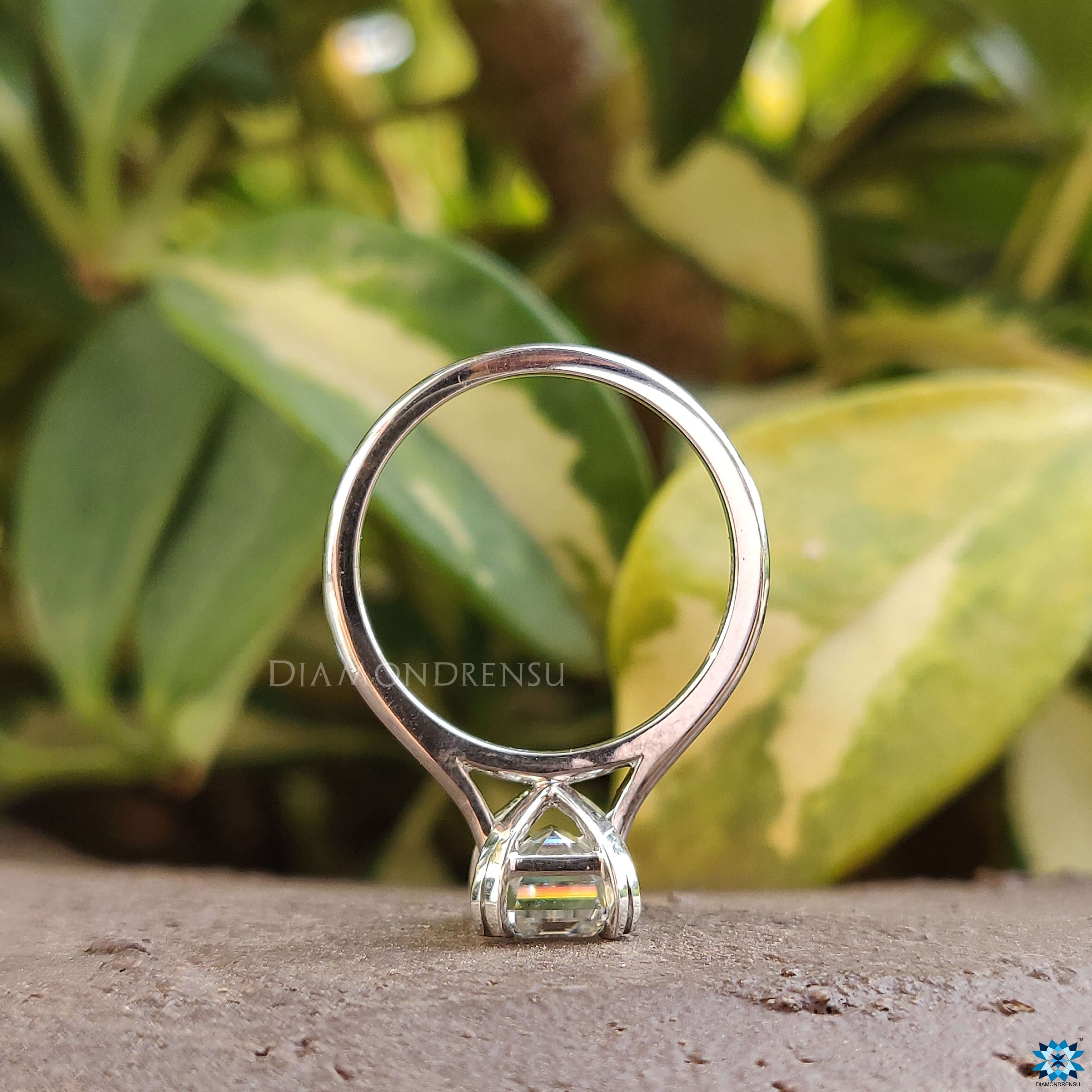 Prong setting white gold ring with emerald cut moissanite.