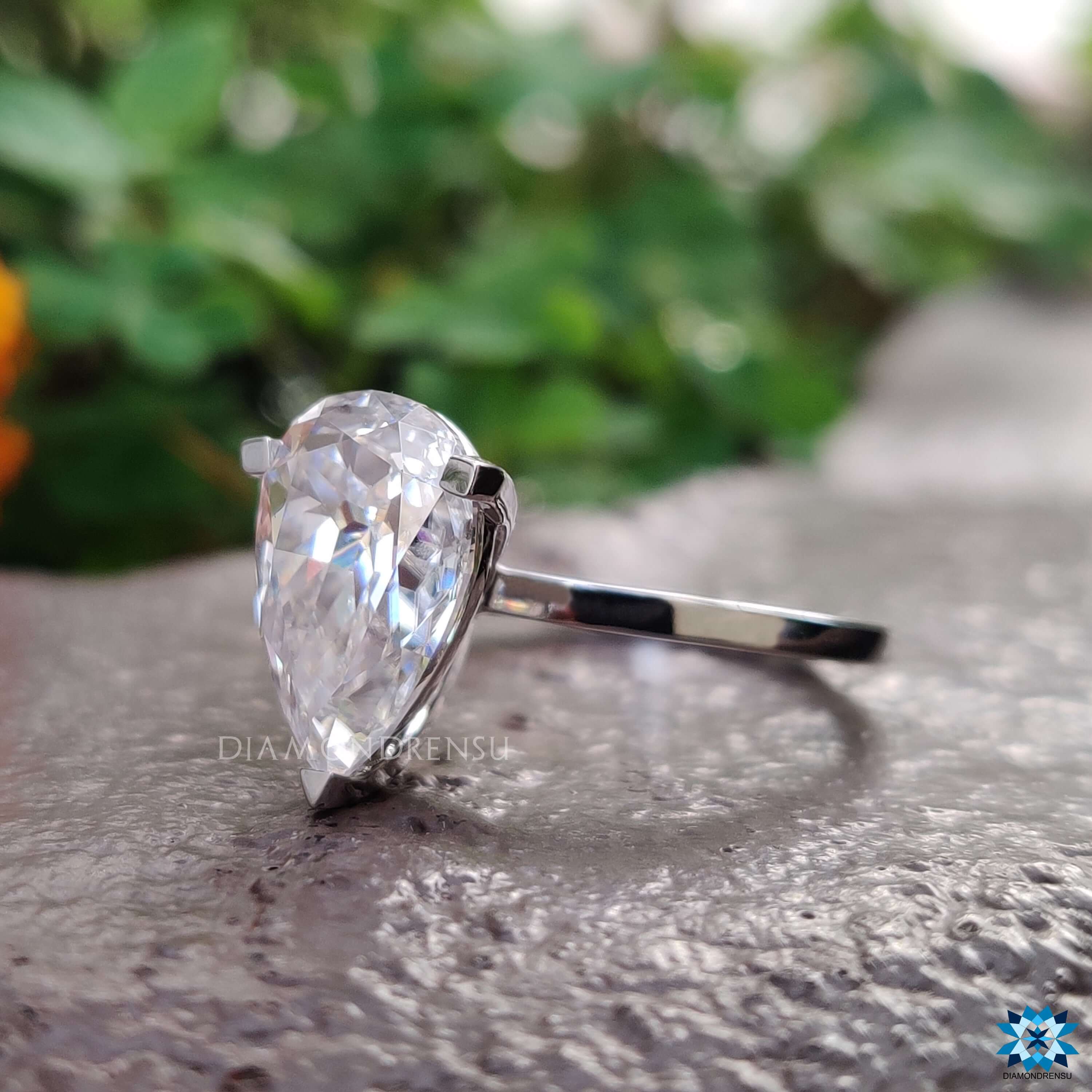 Minimalist moissanite engagement ring with pear cut stone.