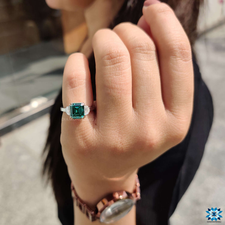 Asscher cut ring with epaulette and round halo accents.