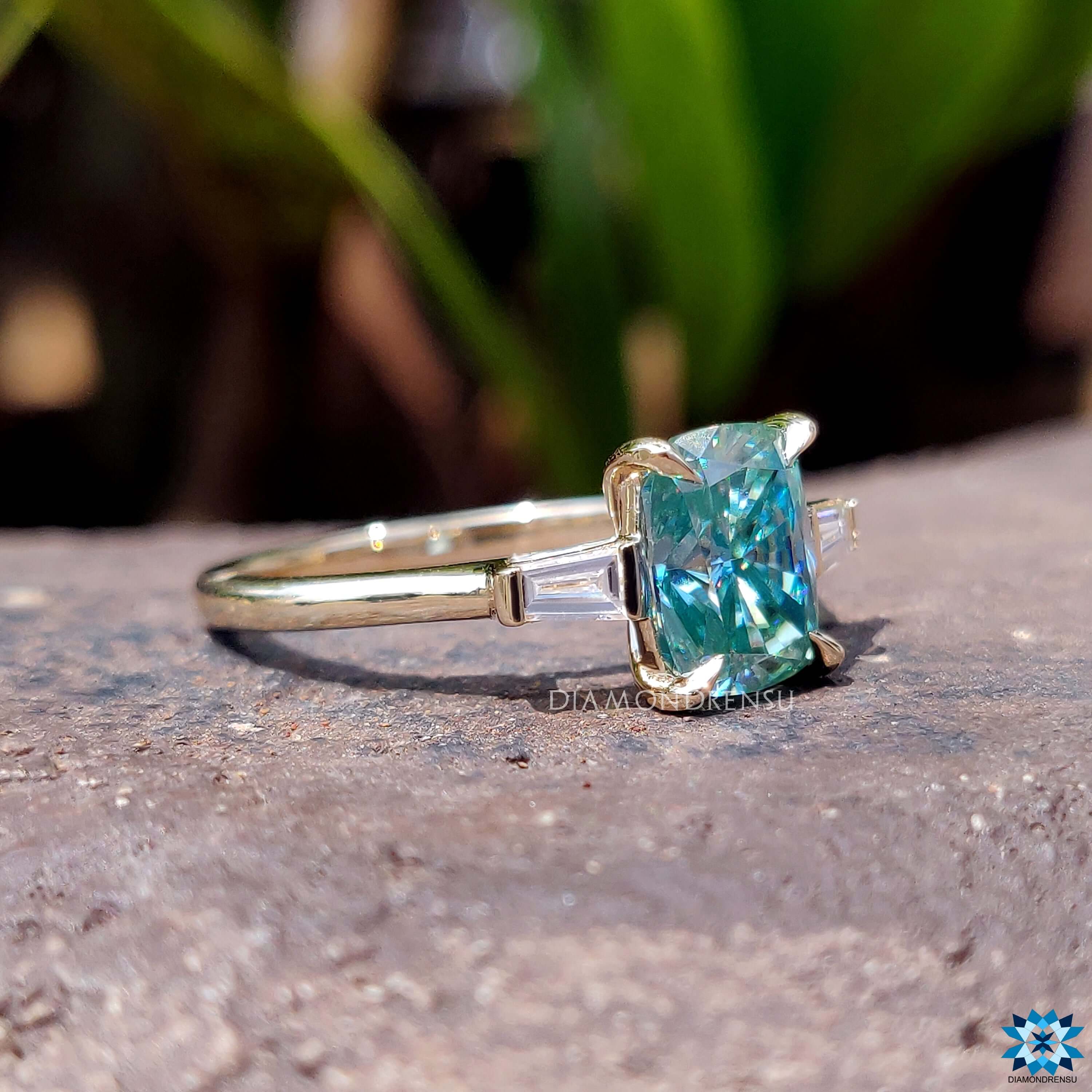 Yellow gold engagement ring with cyan blue moissanite center.