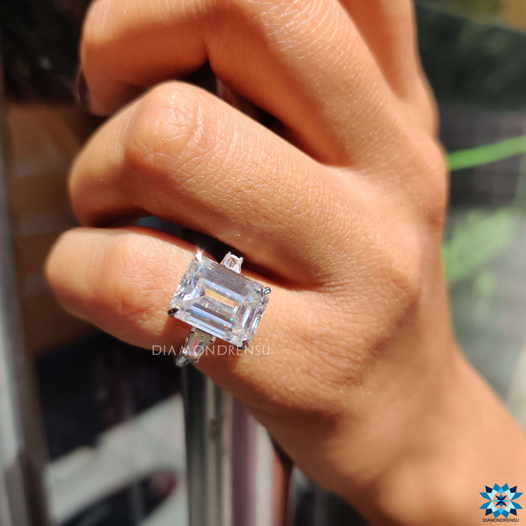 White gold three stone engagement ring with emerald center.