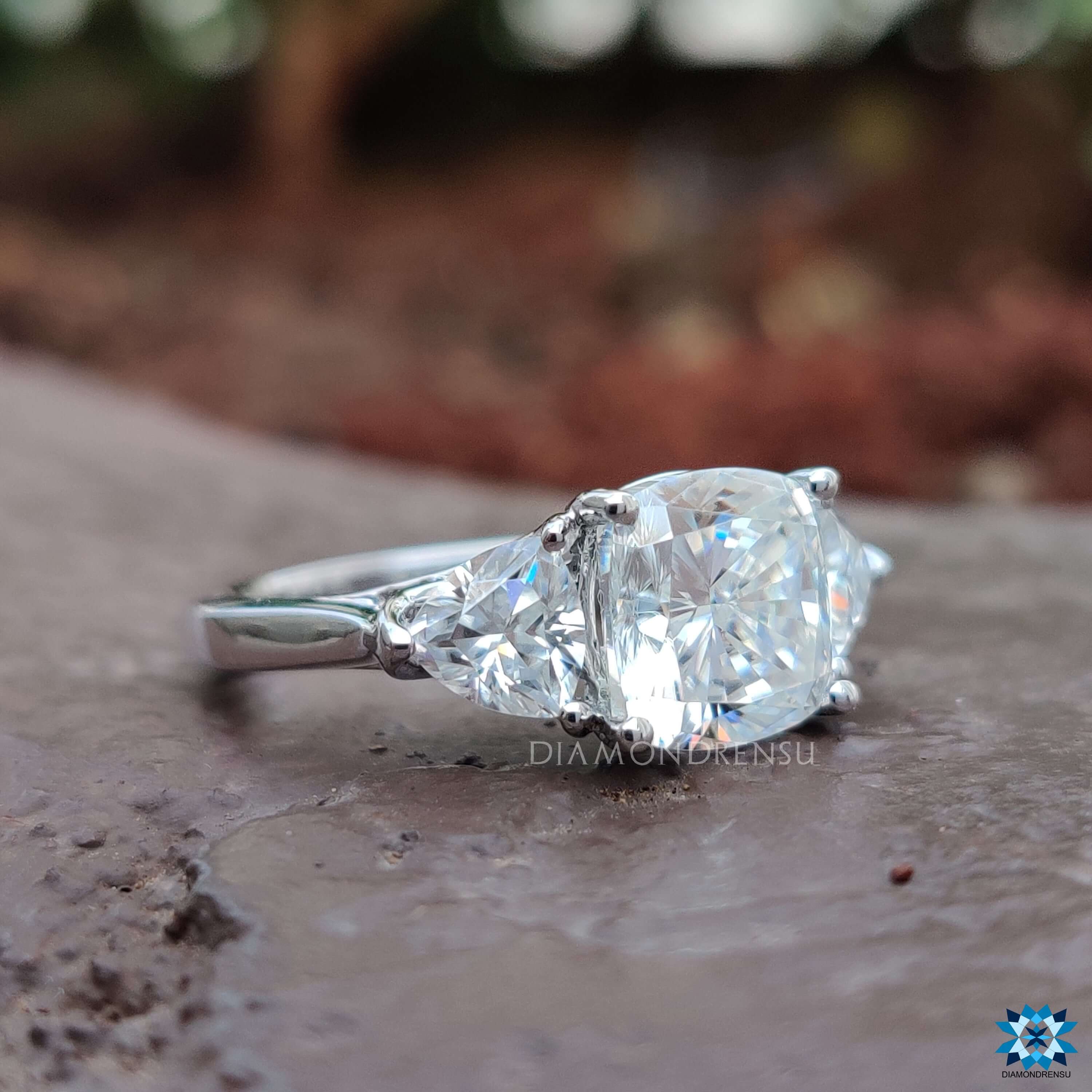 Handmade three stone moissanite ring in white gold.