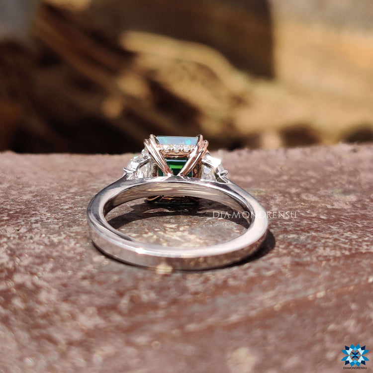Custom engagement ring with green Asscher and epaulette cuts.