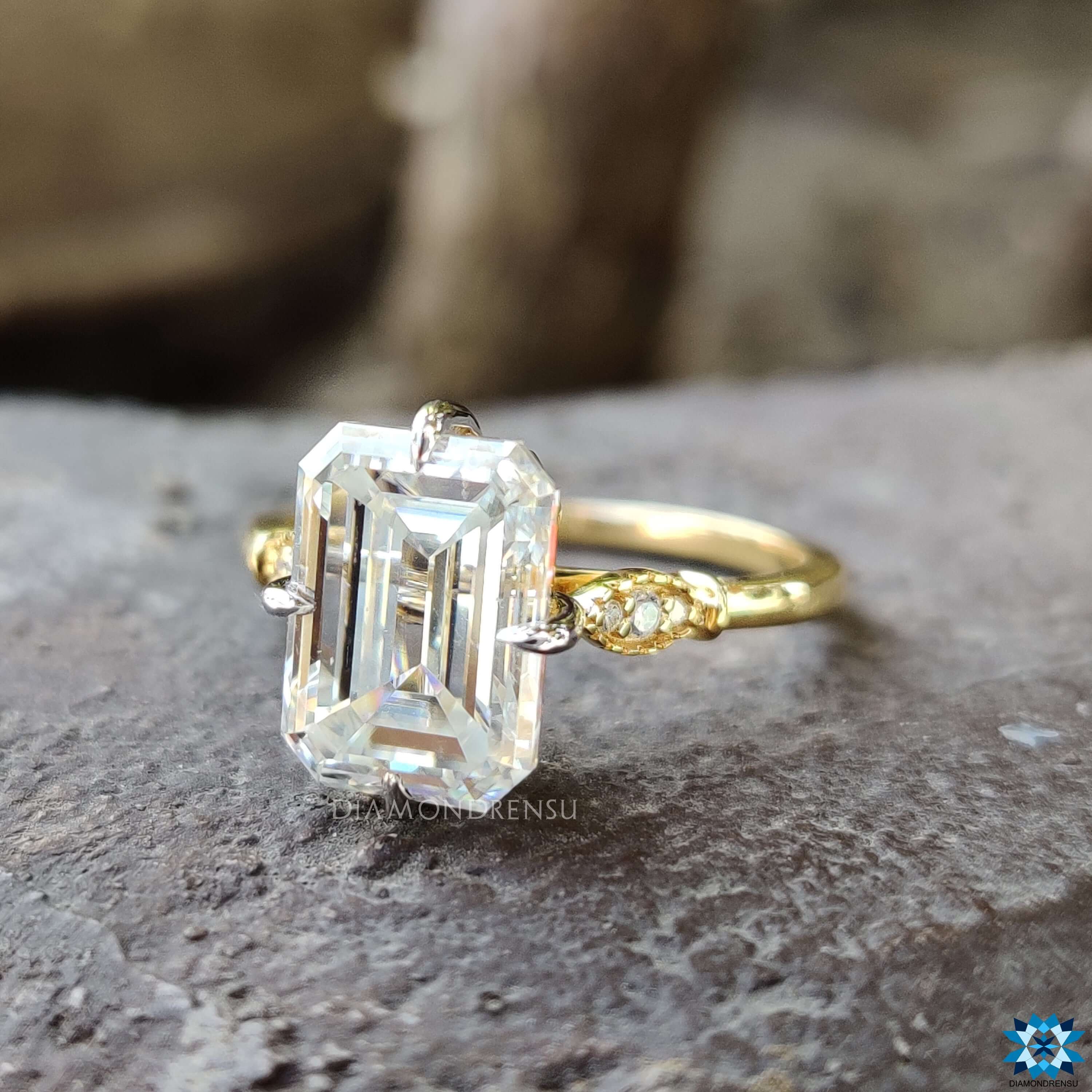 Prong setting engagement ring with emerald cut moissanite.