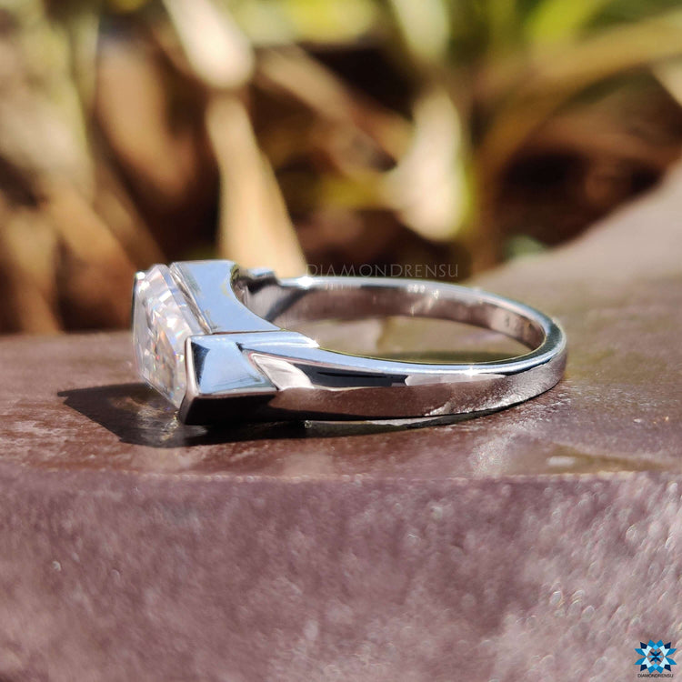 Shield cut moissanite set in an east west layout.