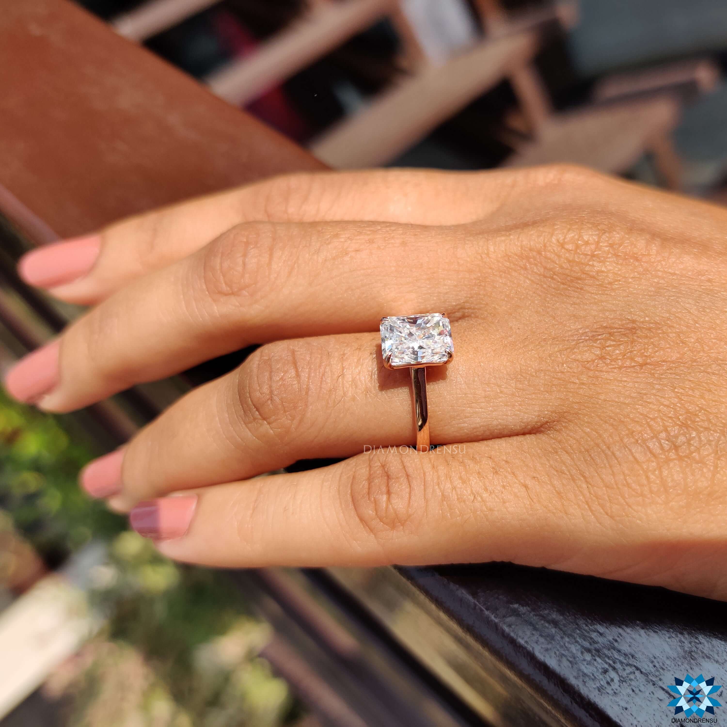Rose gold moissanite ring with four claw prongs.